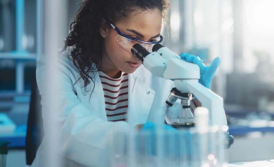 Woman looking in microscope in the medical industries